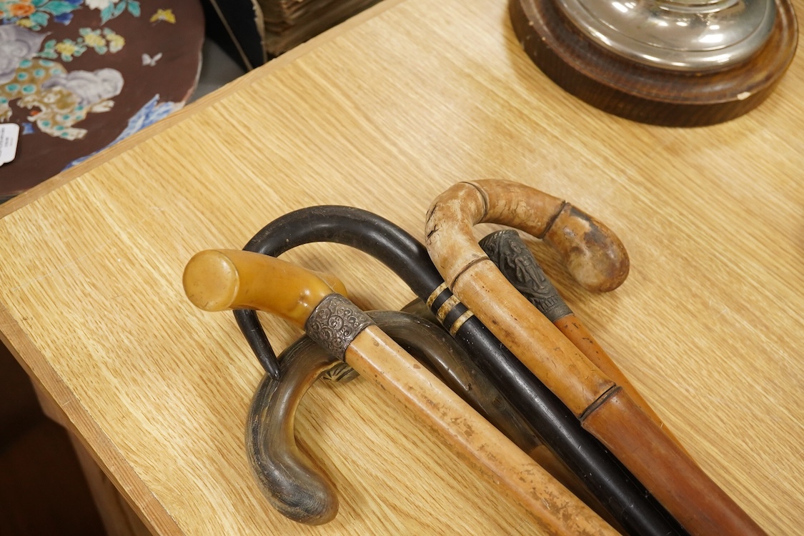 A collection of six various walking canes to include a silver mounted example and one with horn handle